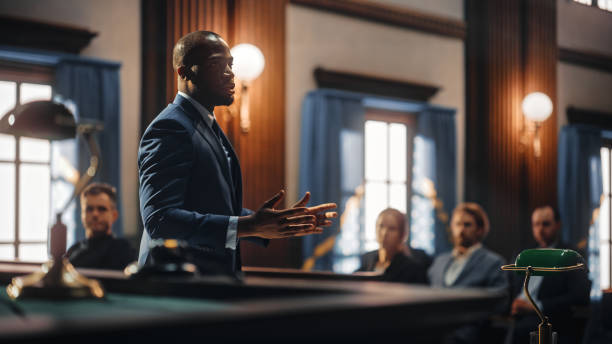 istockphoto-1346156707-612x612 Court of Justice and Law Trial: Male Public Defender Presenting Case, Making Passionate Speech to Judge, Jury. African American Attorney Lawyer Protecting Client's Innocents with Supporting Argument.